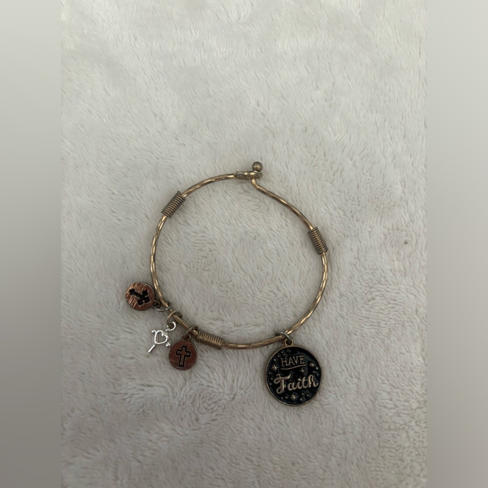 Charm bracelet with cross charms as well as a charm that reads “Have Faith”